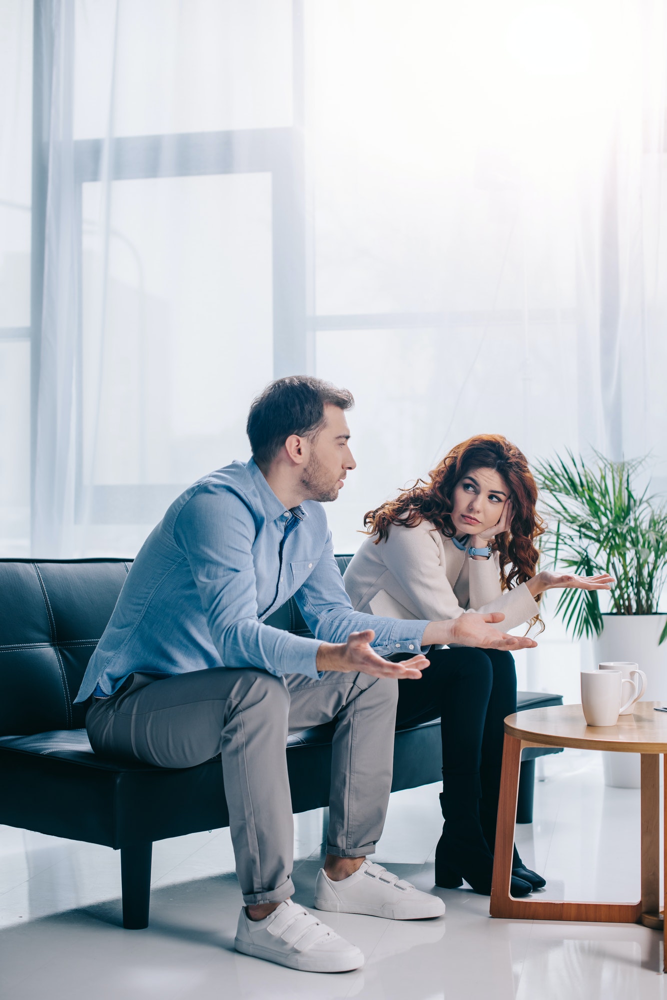 Divorcing young couple arguing in psychiatrist office